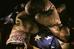 A pair of vintage boxing gloves laying on a flag carefully painted with light