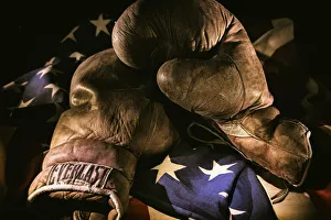 A pair of vintage boxing gloves laying on a flag carefully painted with light A pair of vintage boxing gloves laying on a flag carefully painted with light