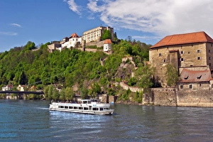 Passau, Germany, a tourist boat sails down the Danube River in front of Veste Oberhaus castle Passau, Germany, a tourist boat sails down the Danube River in front of Veste Oberhaus castle