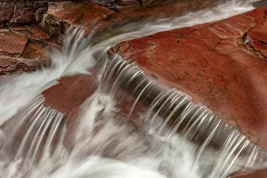 Red rocked bottom of Virginia Creek in Glacier National Park, Montana, USA Red rocked bottom of Virginia Creek in Glacier National Park, Montana, USA
