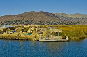 Reed boats of the Uros Islands (Islas Uros) ply the calm waters of lake Titicaca, Peru Reed boats of the Uros Islands (Islas Uros) ply the calm waters of lake Titicaca, Peru