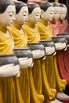 Row of Buddhist monk statues holding alms bowls, Weekend Market, Bangkok, Thailand Row of Buddhist monk statues holding alms bowls, Weekend Market, Bangkok, Thailand