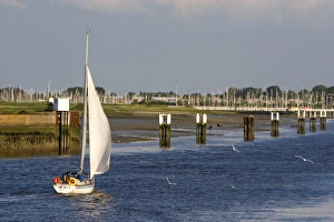 A sail boat at Nieuwpoort harbor entrance in the province of West Flanders, Belgium A sail boat at Nieuwpoort harbor entrance in the province of West Flanders, Belgium