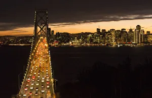 San Francisco California skyline and the Oakland Bay Bridge at evening with traffic San Francisco California skyline and the Oakland Bay Bridge at evening with traffic