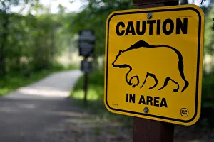 A sign warns visitors about bear danger near Laird River in Hotsprings Provincial Park A sign warns visitors about bear danger near Laird River in Hotsprings Provincial Park