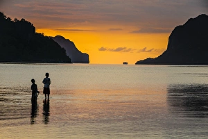 Silhouette of boys fishing at sunset in the bay of El Nido, Bacuit Archipelago, Palawan Silhouette of boys fishing at sunset in the bay of El Nido, Bacuit Archipelago, Palawan