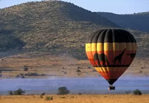 Images Dated 7th June 2003: South Africa, Pilanesburg Game Reserve, Hot air balloon rises above mist-covered