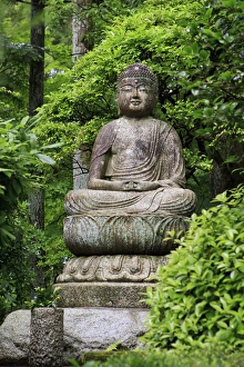 A stone Buddha statue in the grounds of Ryoan-Ji Temple in Kyoto, Japan A stone Buddha statue in the grounds of Ryoan-Ji Temple in Kyoto, Japan