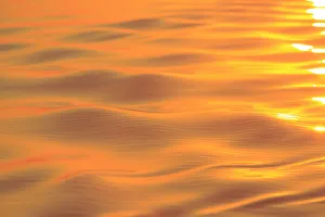 Sunset colors and patterns on small waves in water Sunset colors and patterns on small waves in water