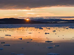 Sunset over fjord with icebergs close to Eqip Glacier in Greenland, Danish Territory Sunset over fjord with icebergs close to Eqip Glacier in Greenland, Danish Territory