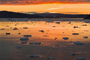 Sunset over fjord with icebergs close to Eqip Sermia glacier in Denmarks overseas territory Sunset over fjord with icebergs close to Eqip Sermia glacier in Denmarks overseas territory