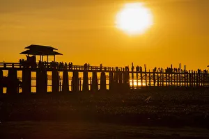 Sunset over the lake near wooden footbridge. U Bein Bridge crossing the Taungthaman Lake Sunset over the lake near wooden footbridge. U Bein Bridge crossing the Taungthaman Lake