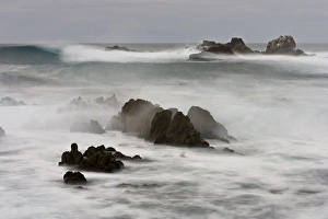 Surf crashing on the California coastline between large rocks Surf crashing on the California coastline between large rocks