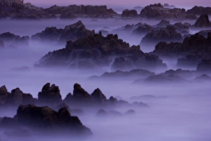 Surf pours over the California coastline at dusk Surf pours over the California coastline at dusk