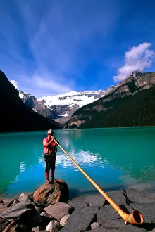 Swiss Alphorn player at Lake Louise in Banff Canada Swiss Alphorn player at Lake Louise in Banff Canada