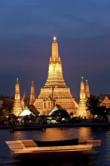Buddhist Gallery: Temple of Dawn (Wat Arun) at dusk with boat on Chao Phraya River, Bangkok, Thailand
