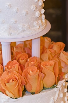 Detail of tiered wedding cake decorated with orange roses Detail of tiered wedding cake decorated with orange roses