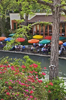 Tourists dining in outdoor cafe under colorful umbrellas on the famous River Walk Tourists dining in outdoor cafe under colorful umbrellas on the famous River Walk