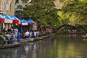 Tourists dining in outdoor cafe on the famous River Walk along the San Antonio River Tourists dining in outdoor cafe on the famous River Walk along the San Antonio River