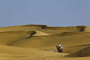 Tourists riding camels into Thar Desert near Jodhpur, India Tourists riding camels into Thar Desert near Jodhpur, India