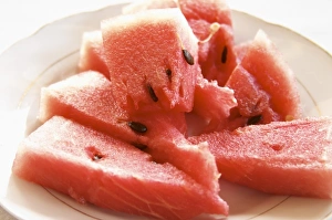 Triangular pieces of red water melon Shalqi on a white plate. Berat lower town. Albania Triangular pieces of red water melon Shalqi on a white plate. Berat lower town. Albania
