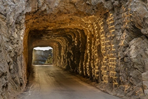 Tunnel on Iron Mountain Road lit by setting sun with view of Mount Rushmore near Keystone Tunnel on Iron Mountain Road lit by setting sun with view of Mount Rushmore near Keystone