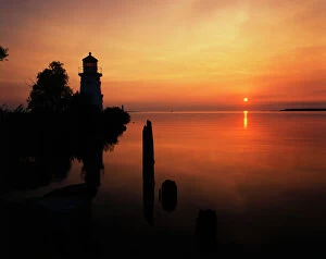 Images Dated 12th February 2013: USA, Michigan, Cheboygan, View of sea and lighthouse at sunset