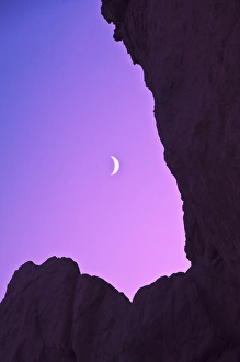 USA, Oregon. Crescent moon framed by sea stacks at twilight USA, Oregon. Crescent moon framed by sea stacks at twilight