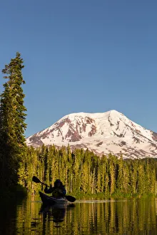 USA, Washington State. Woman kayaker paddles on calm, scenic Takhlakh Lake with Mt USA, Washington State. Woman kayaker paddles on calm, scenic Takhlakh Lake with Mt