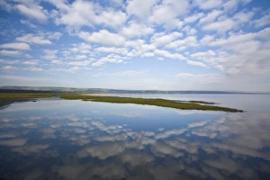 View of sky and clouds reflected in the waters of Lake Nakuru, Kenya as lesser flamingoes View of sky and clouds reflected in the waters of Lake Nakuru, Kenya as lesser flamingoes
