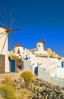 The white buildings and the windmills on the mountain cliffs of Oia, Santorini, Greece The white buildings and the windmills on the mountain cliffs of Oia, Santorini, Greece