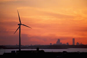 Clean Energy Gallery: Wind Turbine in Hull, Massachusetts. The Boston skyline is in the distance. Sunset
