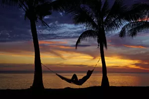 Images Dated 30th October 2011: Woman in hammock, and palm trees at sunset, Coral Coast, Viti Levu, Fiji, South Pacific