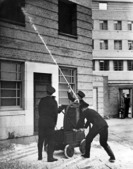 Firefighters operating old pump at special drill display