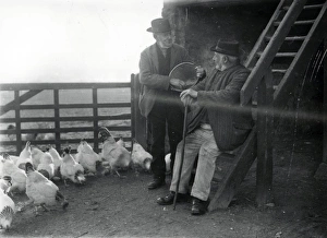 Two country folk feeding chickens in farm in Sussex Two country folk feeding chickens in farm in Sussex