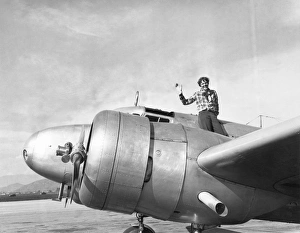 AMELIA EARHART (1897-1937). American aviator. Sitting atop her Electra 10E in Los Angeles AMELIA EARHART (1897-1937). American aviator. Sitting atop her Electra 10E in Los Angeles