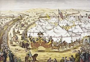 AMERICAN CIRCUS, c1874. The Grand Layout. Circus parade around tents with a crowd watching alongside a railroad train