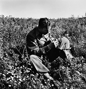 An American soldier in a field in Italy putting flowers in his helmet on Easter Sunday An American soldier in a field in Italy putting flowers in his helmet on Easter Sunday