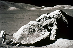 APOLLO 17: BOULDER, 1972. Astronaut Harrison H. Jack Schmitt standing by a huge split APOLLO 17: BOULDER, 1972. Astronaut Harrison H. Jack Schmitt standing by a huge split