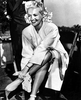 BETTY GRABLE (1916-1973). American actress. Putting on a pair of nylon stockings, c1940 BETTY GRABLE (1916-1973). American actress. Putting on a pair of nylon stockings, c1940