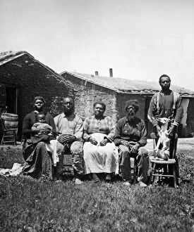 BLACK HOMESTEADERS. A black family photographed in 1887 before their homestead