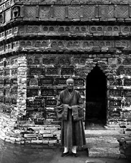 A Buddhist monk standing outside the entrance of the Iron Pagoda, built in the mid-11th century