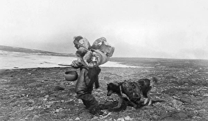 CANADA: ESKIMO. A woman and her dog walking through the wilderness in the summer CANADA: ESKIMO. A woman and her dog walking through the wilderness in the summer
