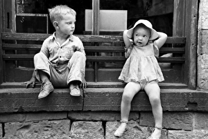 CHILDREN, 1940. Children of gold miners sitting on a store window sill, Mogollon CHILDREN, 1940. Children of gold miners sitting on a store window sill, Mogollon