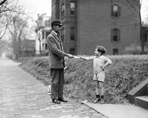CHRISTMAS, 1920. A boy handing a mail carrier a letter for Santa Claus. Photograph CHRISTMAS, 1920. A boy handing a mail carrier a letter for Santa Claus. Photograph