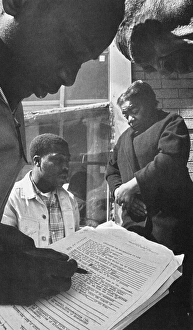 Two civil rights activists help an African American couple from Mississippi register to Two civil rights activists help an African American couple from Mississippi register to