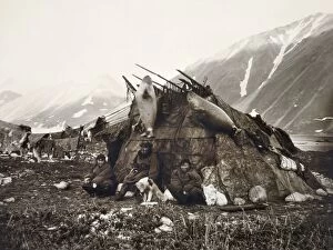 ESKIMO DWELLING, c1899. A group of three Inuits sitting in front of their house