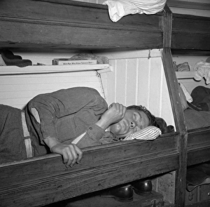 FISHERMAN, 1943. A young fishermen taking a nap on board the fishing boat 'Alden' FISHERMAN, 1943. A young fishermen taking a nap on board the fishing boat 'Alden'