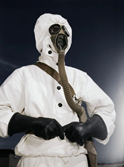 GAS MASK, 1942. A sailor wearing protective clothing and a gas mask designed for GAS MASK, 1942. A sailor wearing protective clothing and a gas mask designed for