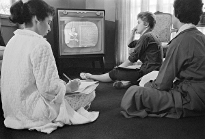 Three high school girls in Little Rock, Arkansas, sitting on the floor while learning a Three high school girls in Little Rock, Arkansas, sitting on the floor while learning a